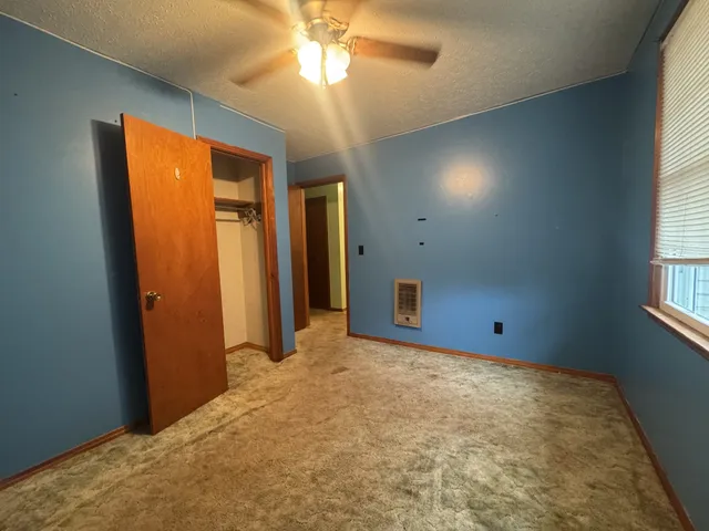 en empty room with window and a ceiling fan