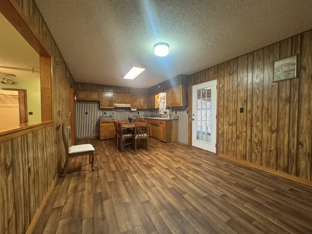 a view of a room with chairs and wooden floor