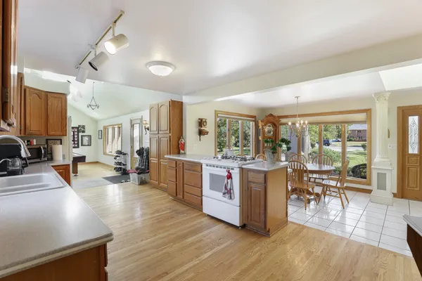 a living room with stainless steel appliances kitchen island granite countertop furniture and a wooden floors