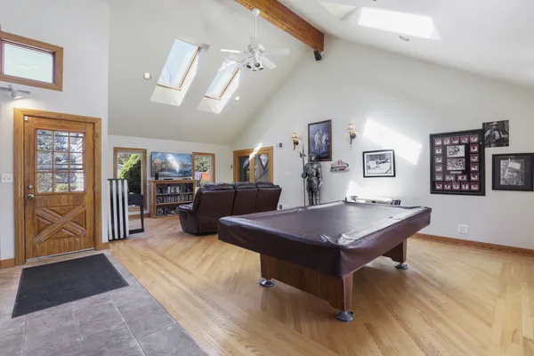 a room with furniture pool table and window