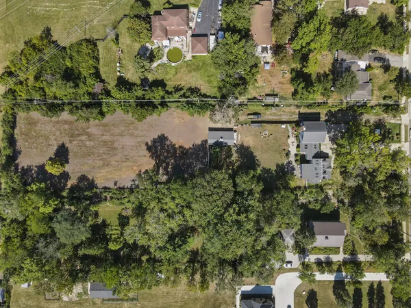 a front view of a house with a garden and trees