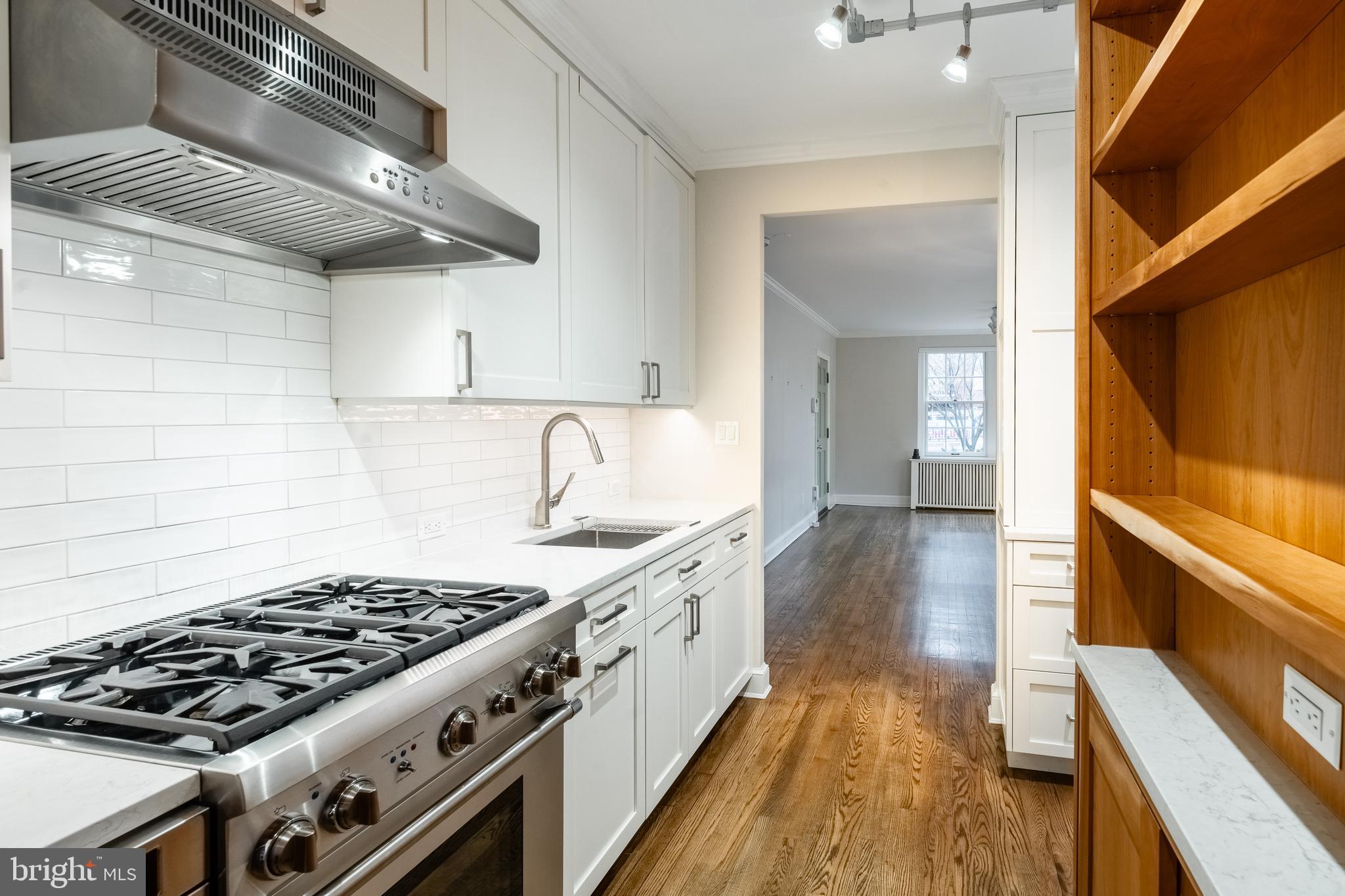 1127 C Street Southeast, Unit 1 Washington, DC 20003 - Photo 12 of 26 a kitchen with a stove and a wooden floor