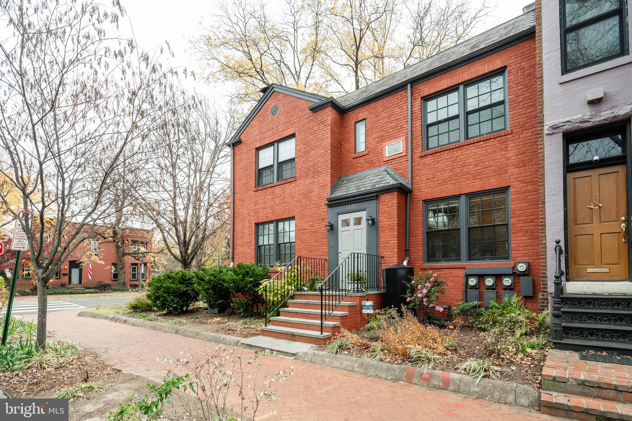 1127 C Street Southeast, Unit 1 Washington, DC 20003 - Photo 2 of 26 a view of a brick house with many windows next to a road