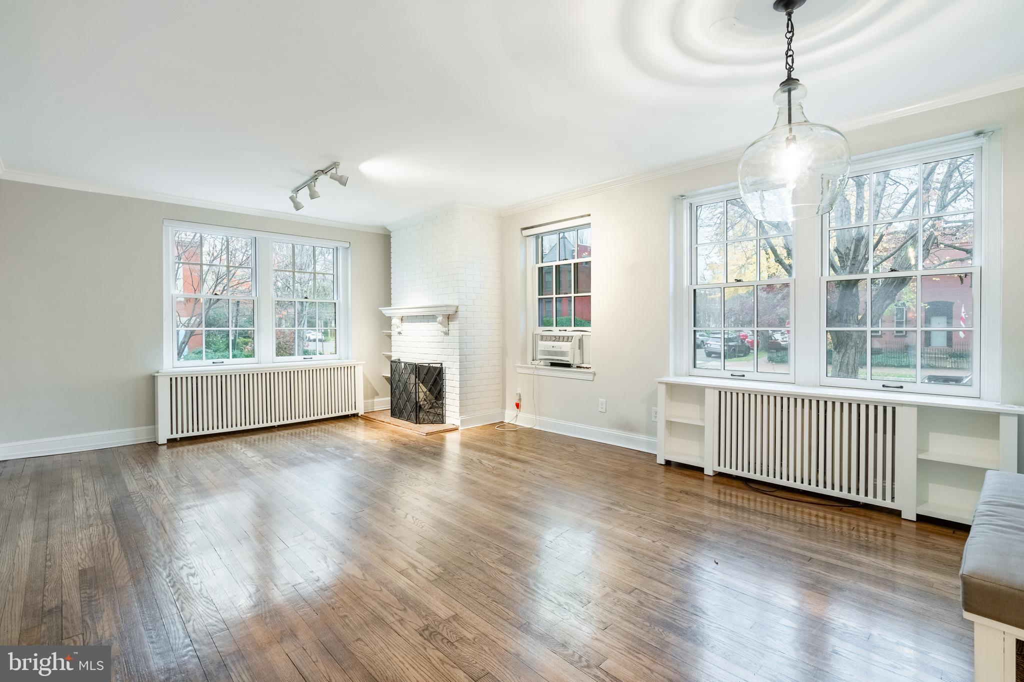 1127 C Street Southeast, Unit 1 Washington, DC 20003 - Photo 7 of 26 a view of an empty room with wooden floor and a window