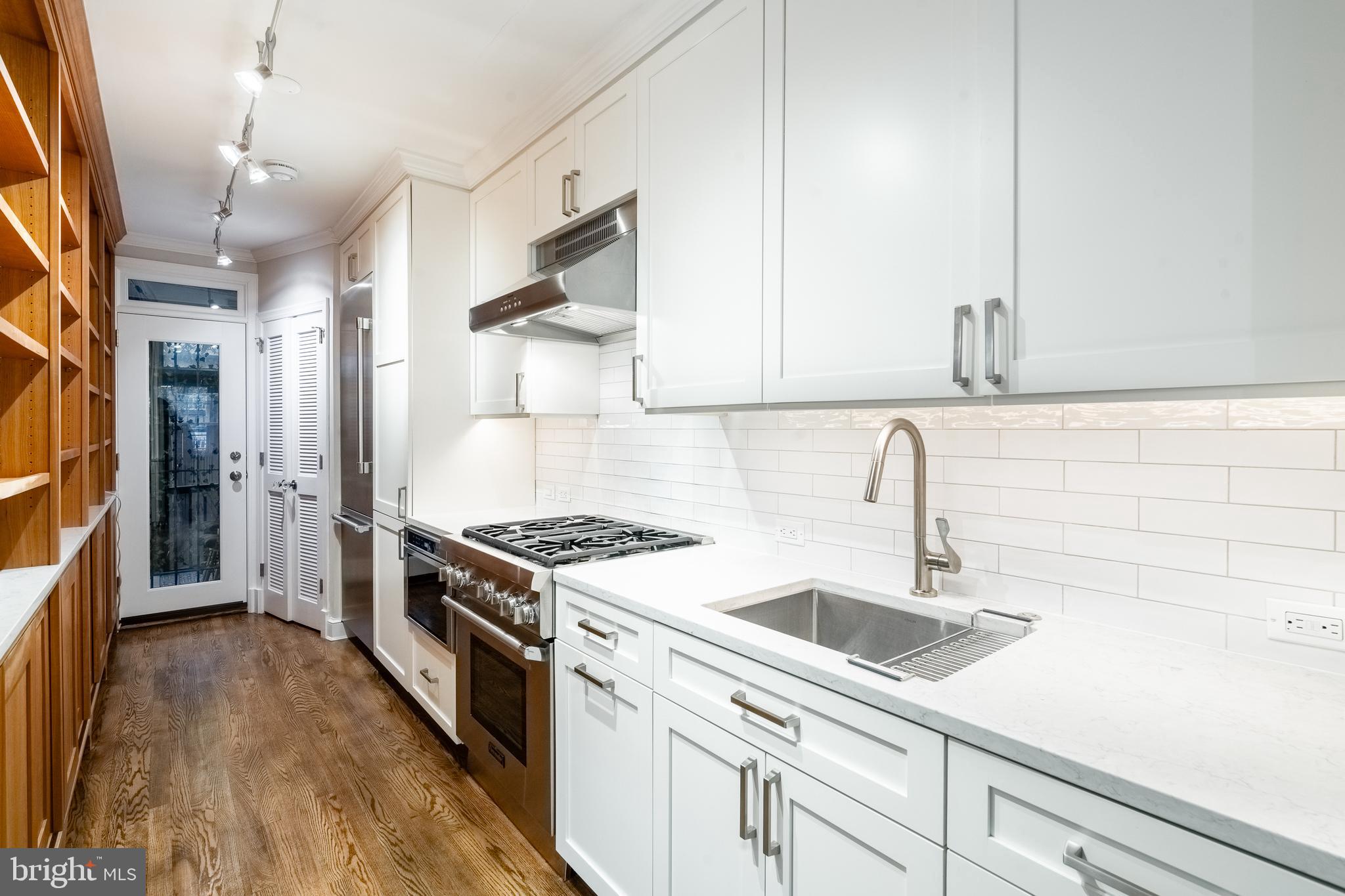 1127 C Street Southeast, Unit 1 Washington, DC 20003 - Photo 8 of 26 a kitchen with a sink dishwasher a stove and a refrigerator with wooden floor