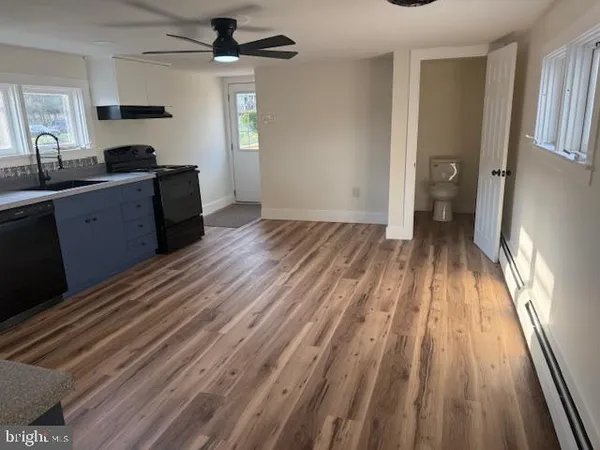 a kitchen with a sink and wooden floor