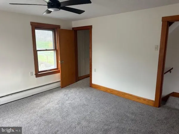 an empty room with windows and closet