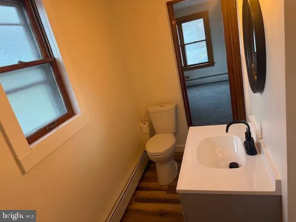 a bathroom with a sink and mirror with toilet