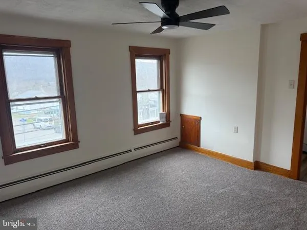 an empty room with windows and cabinet