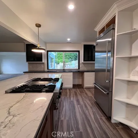 a kitchen with a stove a refrigerator and a microwave