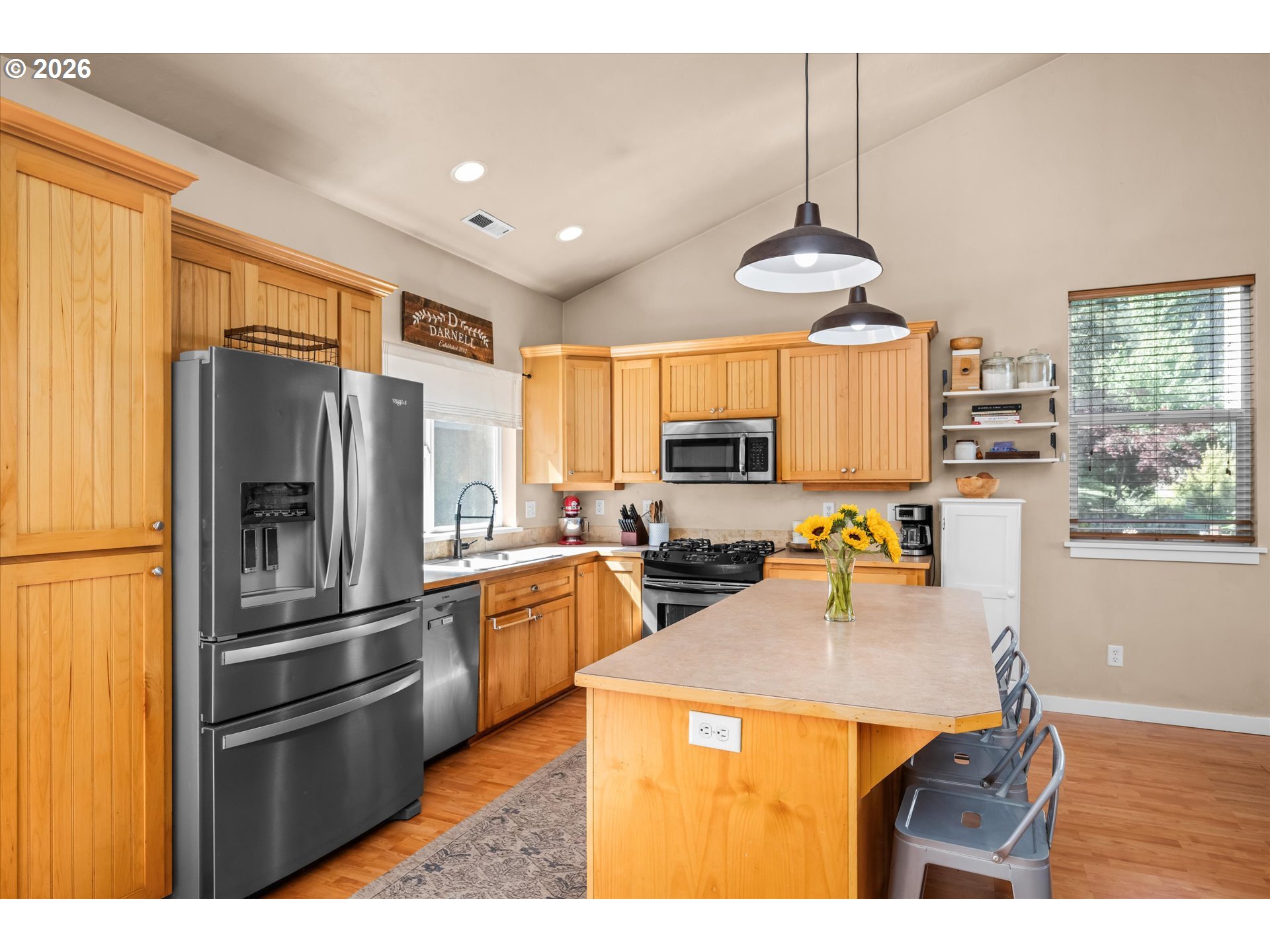 277 South 67th Court Springfield, OR 97478 - Photo 9 of 44 a kitchen with stainless steel appliances a refrigerator a stove a sink a center island and furniture