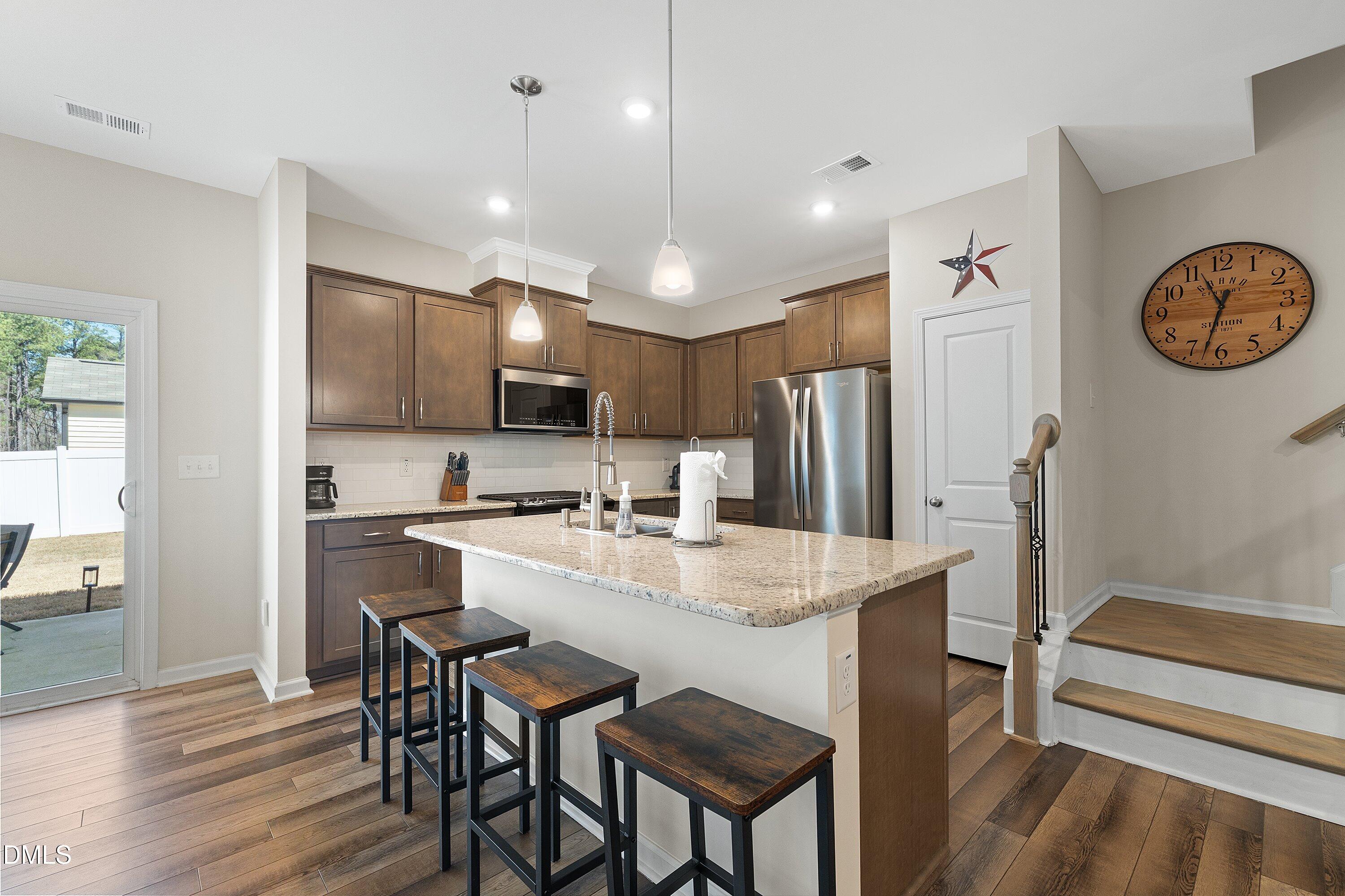 1004 Everglades Way Durham, NC 27713 - Photo 14 of 40 a kitchen with stainless steel appliances granite countertop a stove a refrigerator a kitchen island a table and chairs