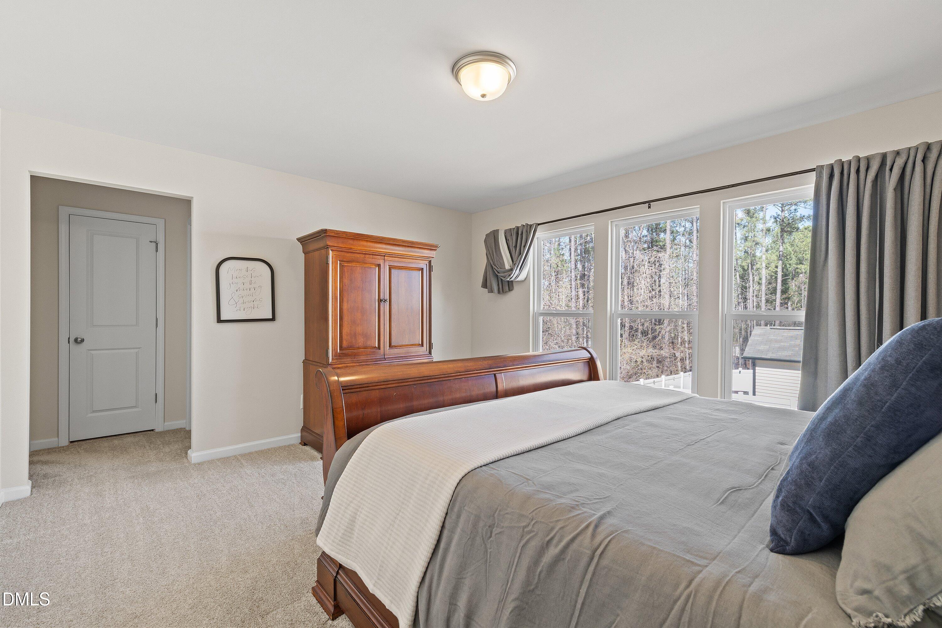 1004 Everglades Way Durham, NC 27713 - Photo 30 of 40 a bedroom with a large bed and a large window