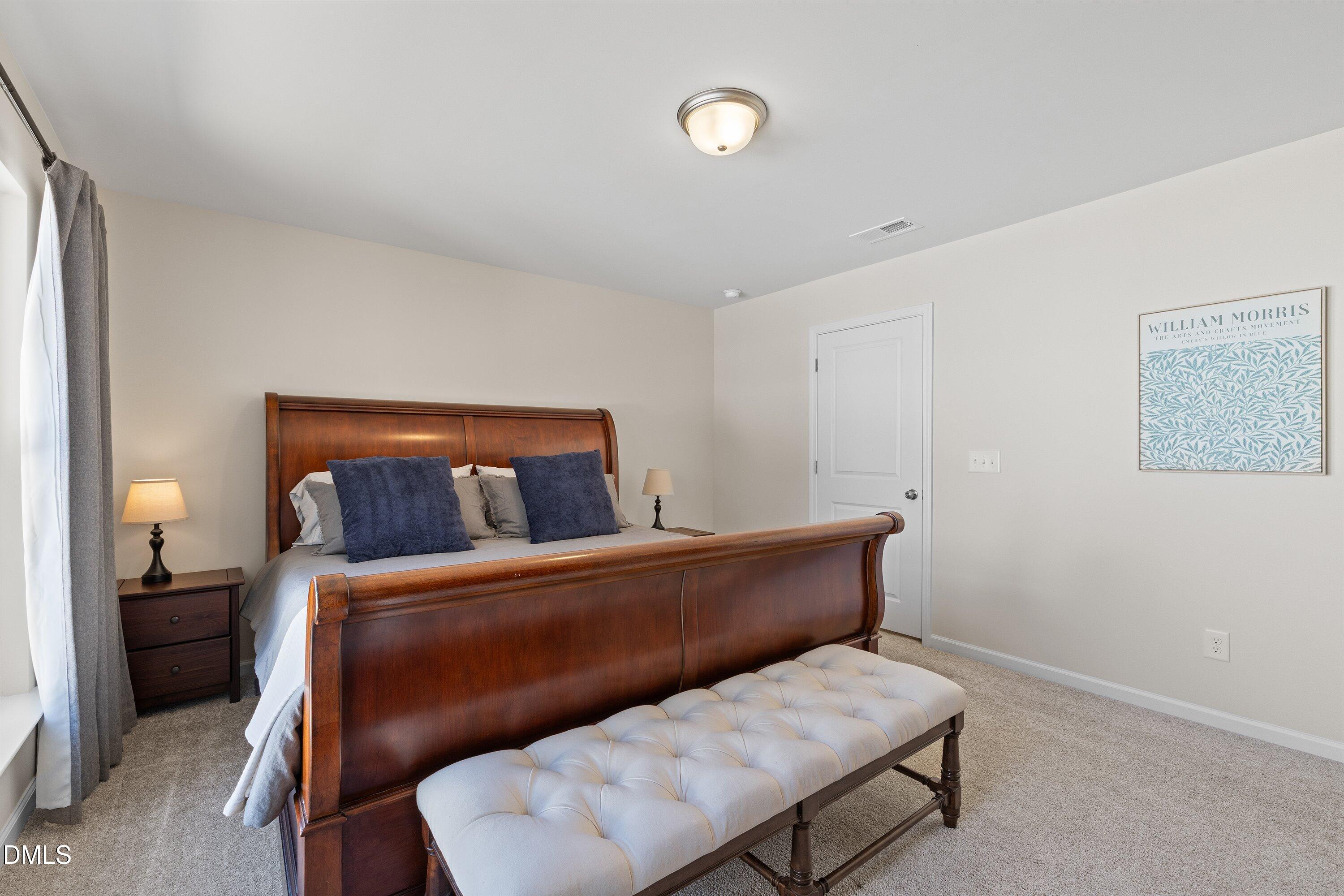 1004 Everglades Way Durham, NC 27713 - Photo 32 of 40 a bedroom with a bed and a lamp on dresser