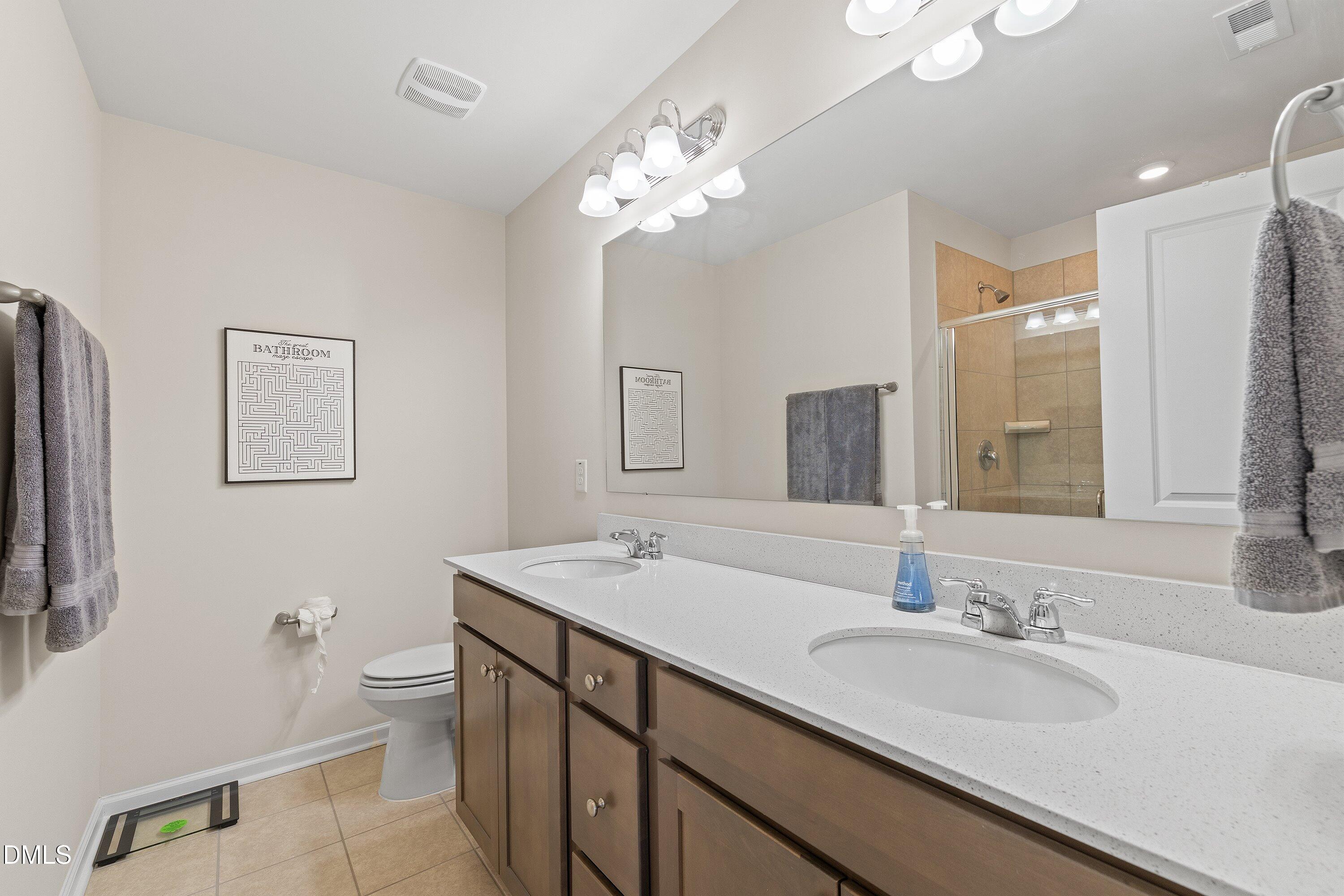 1004 Everglades Way Durham, NC 27713 - Photo 34 of 40 a bathroom with a double vanity sink and a mirror