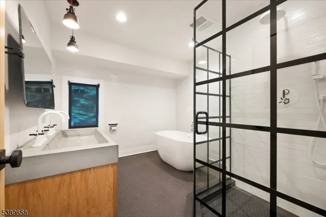 a bathroom with a sink mirror and a shower