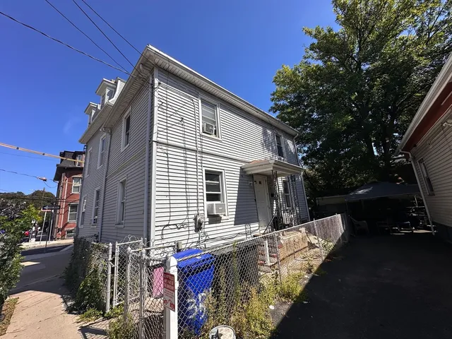 a front view of house with yard and trees around