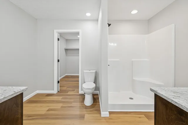 a bathroom with a granite countertop sink toilet and shower