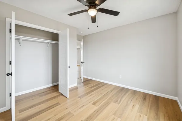 a view of an empty room with window and a ceiling fan