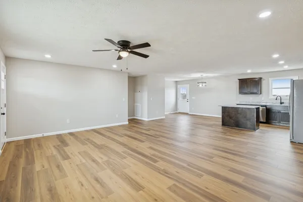 a view of empty room with wooden floor and fireplace