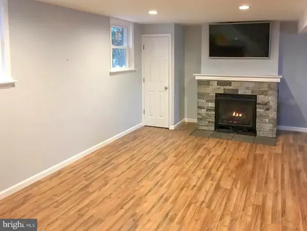 a view of empty room with a fireplace and wooden floor