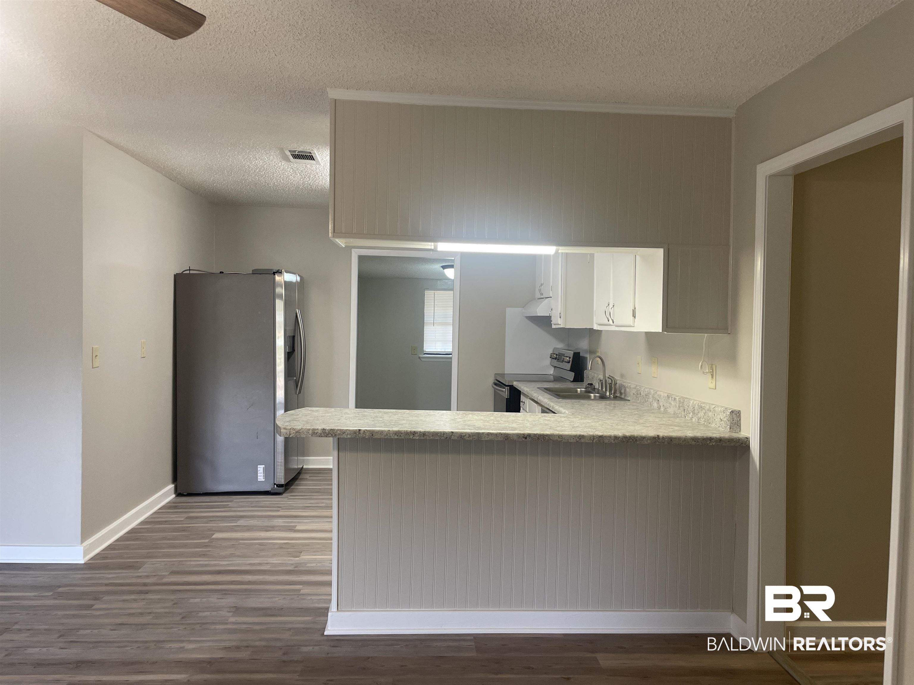28414 Highway 31 Flomaton, AL 36441 - Photo 5 of 11 Kitchen with wood finished floors, visible vents, a sink, stainless steel appliances, and light countertops