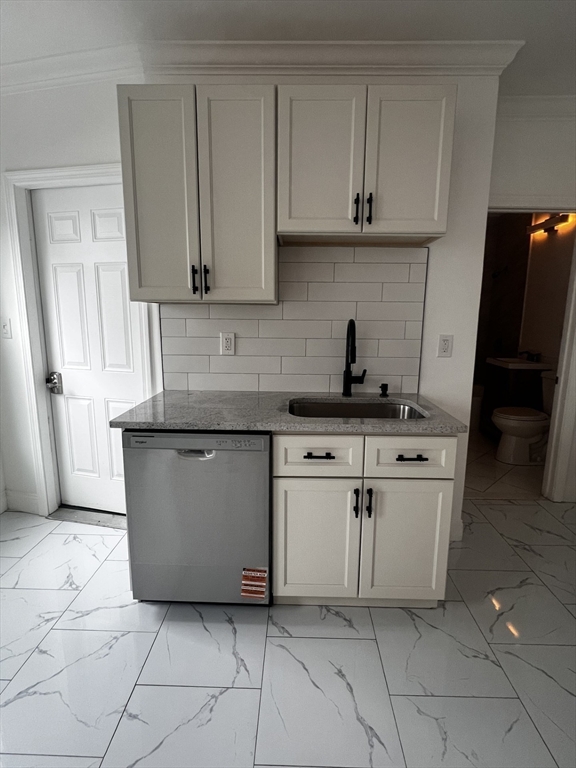 19 Reeves Street Worcester, MA 01607 - Photo 6 of 30 a kitchen with white cabinets a sink and dishwasher