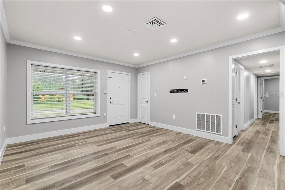 5804 Wolf Road Orlando, FL 32808 - Photo 11 of 24 a view of an empty room with wooden floor and a window