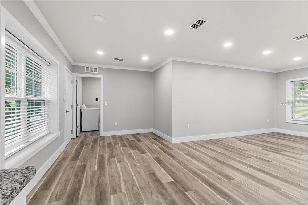 5804 Wolf Road Orlando, FL 32808 - Photo 16 of 24 an empty room with wooden floor and windows