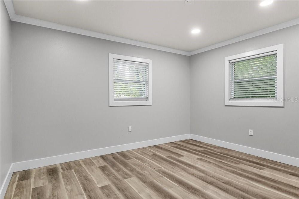 5804 Wolf Road Orlando, FL 32808 - Photo 17 of 24 a view of an empty room with wooden floor and a window