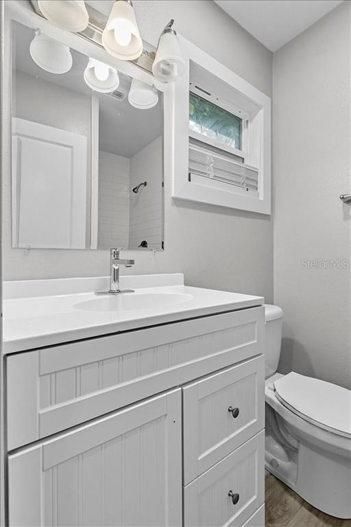 5804 Wolf Road Orlando, FL 32808 - Photo 19 of 24 a bathroom with a toilet sink and mirror