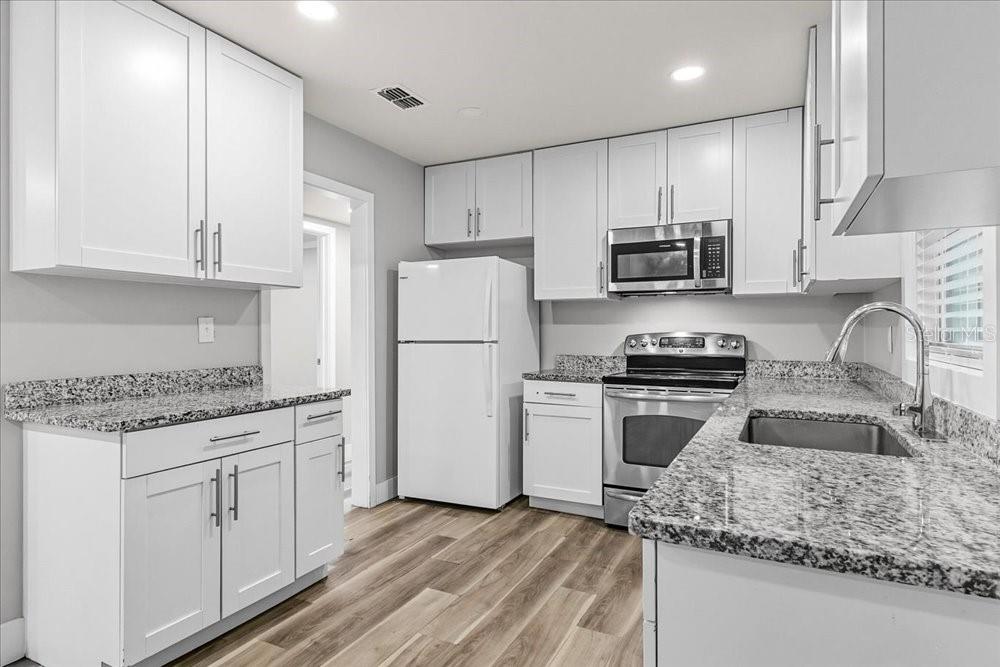 5804 Wolf Road Orlando, FL 32808 - Photo 5 of 24 a kitchen with refrigerator and cabinets