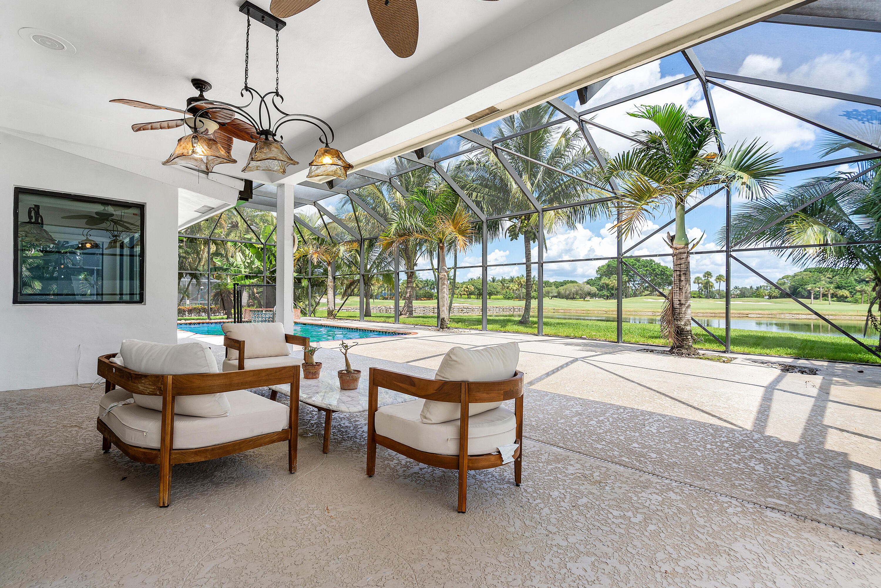 10391 Boca Woods Lane Boca Raton, FL 33428 - Photo 30 of 60 a living room with patio furniture and a chandelier