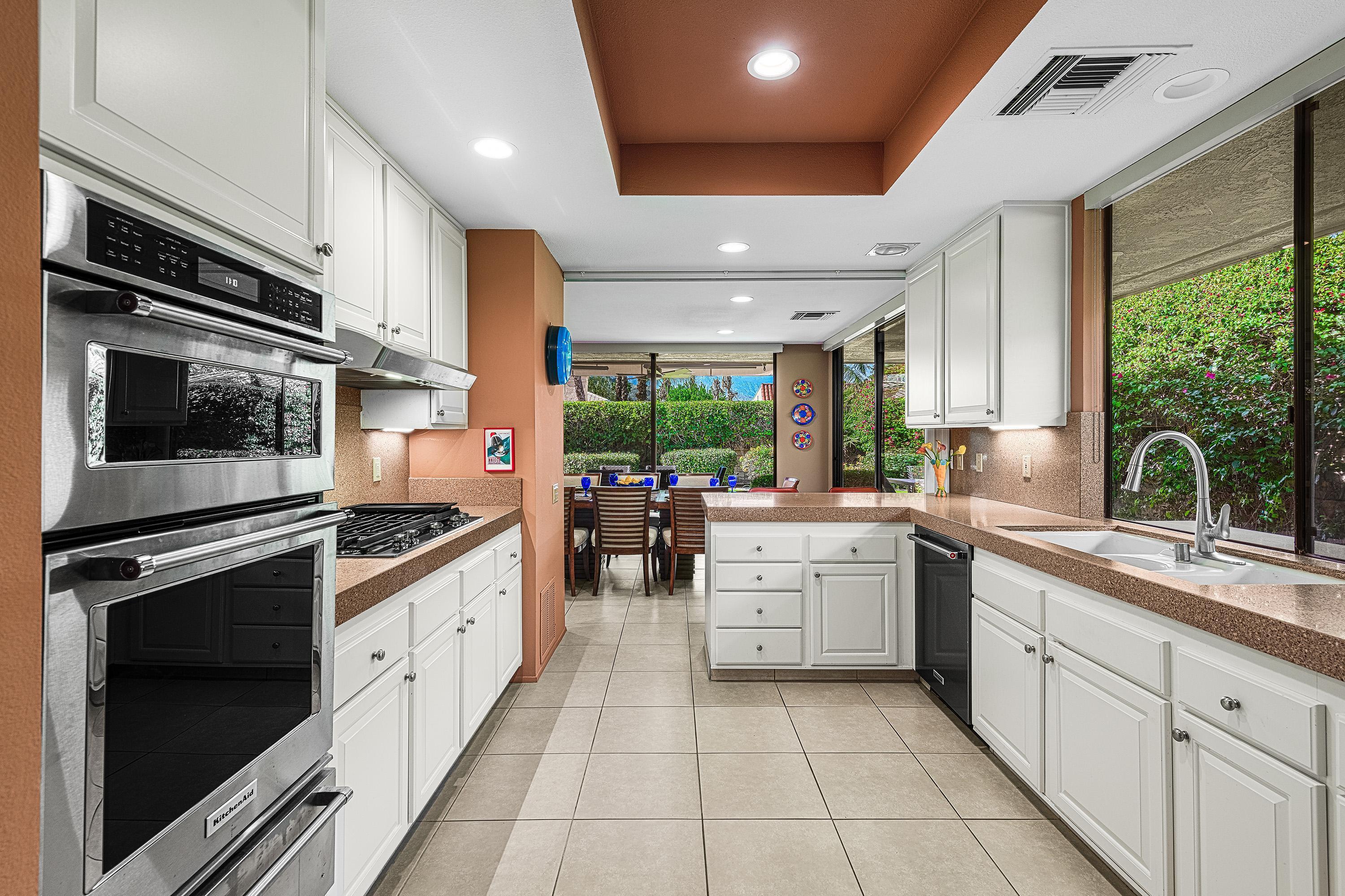 32 Cornell Drive Rancho Mirage, CA 92270 - Photo 18 of 50 a kitchen with stainless steel appliances granite countertop a stove a sink and a microwave