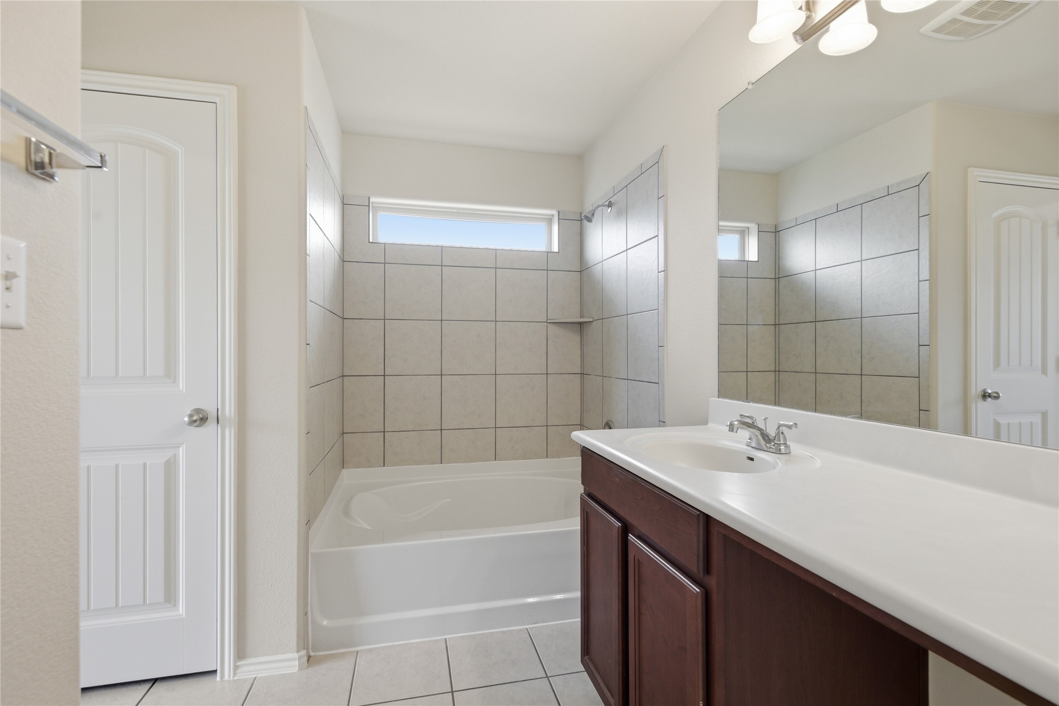 19325 Stokes Lane Pflugerville, TX 78660 - Photo 12 of 24 Full bathroom with vanity, light tile patterned floors, and shower / washtub combination