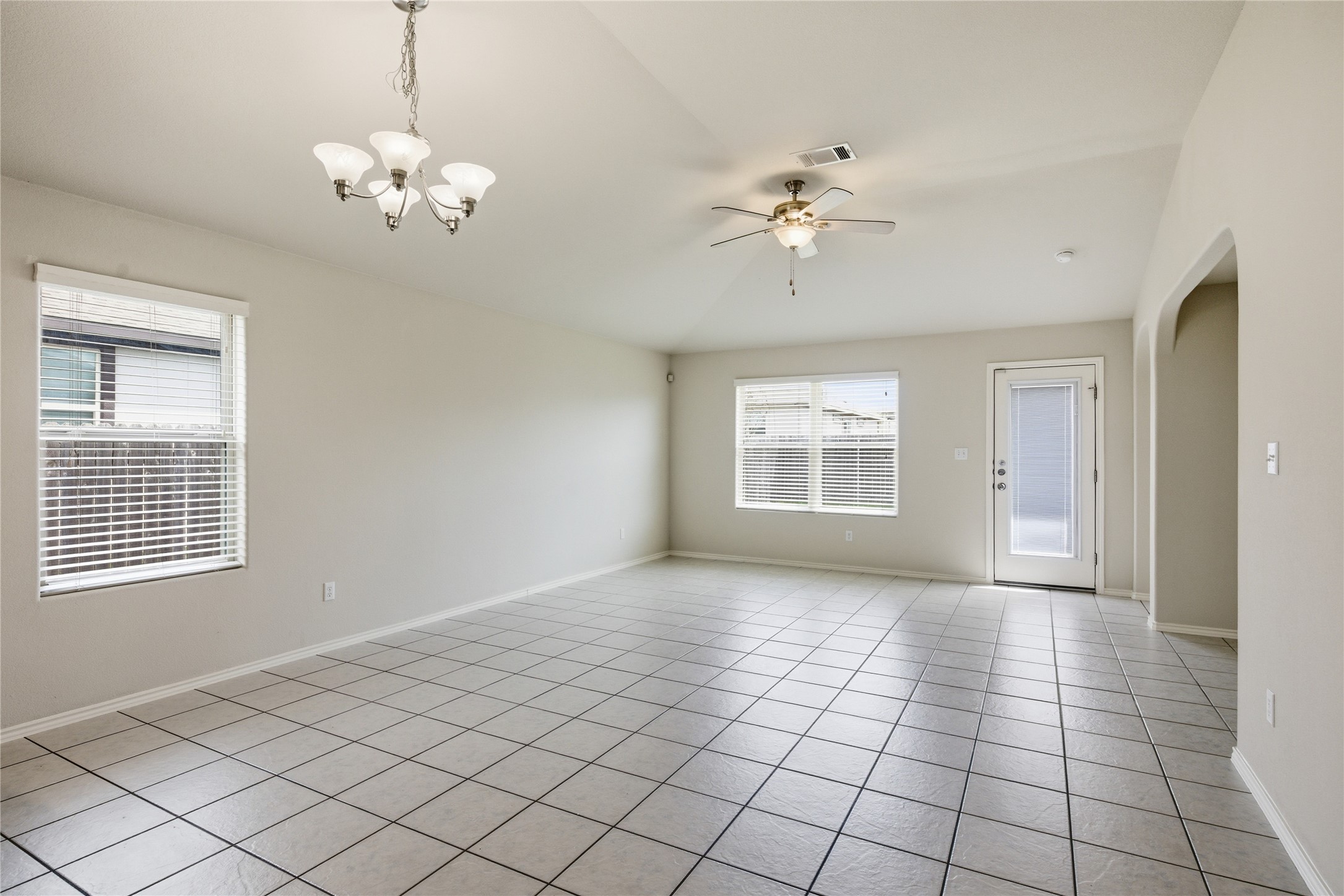 19325 Stokes Lane Pflugerville, TX 78660 - Photo 24 of 24 Spare room featuring a ceiling fan, vaulted ceiling, hanging lights, light tile patterned floors, and arched walkways