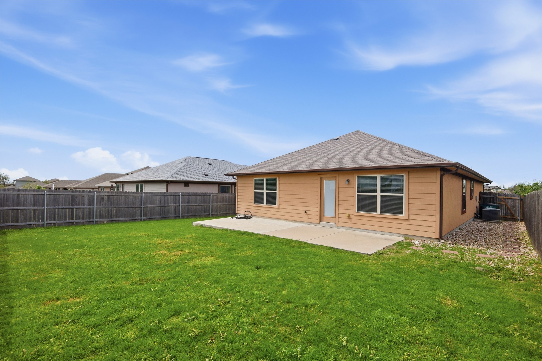 19325 Stokes Lane Pflugerville, TX 78660 - Photo 4 of 24 Back of house with a patio, a fenced backyard, and roof with shingles