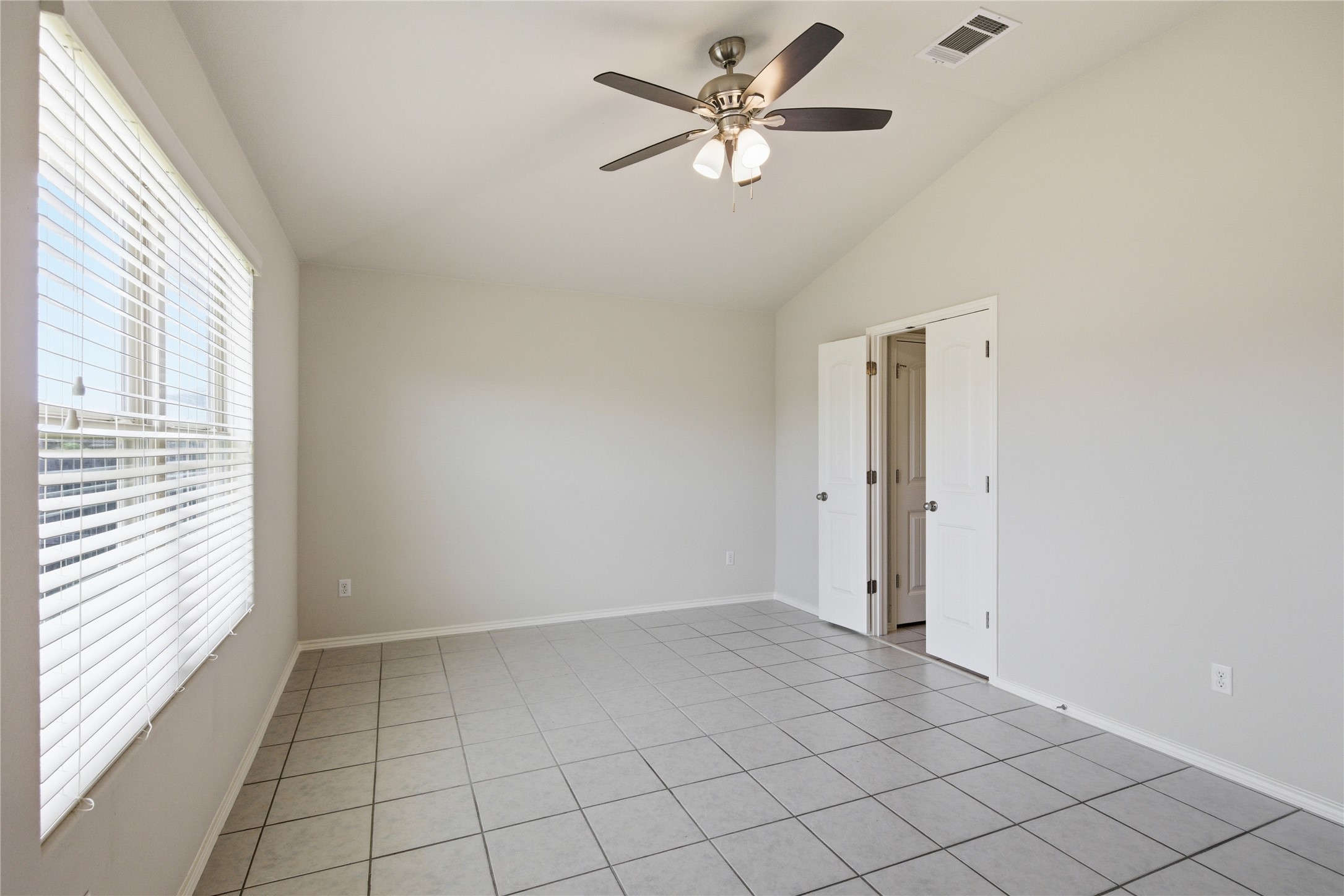 19325 Stokes Lane Pflugerville, TX 78660 - Photo 8 of 24 Spare room with a ceiling fan, light tile patterned floors, and lofted ceiling