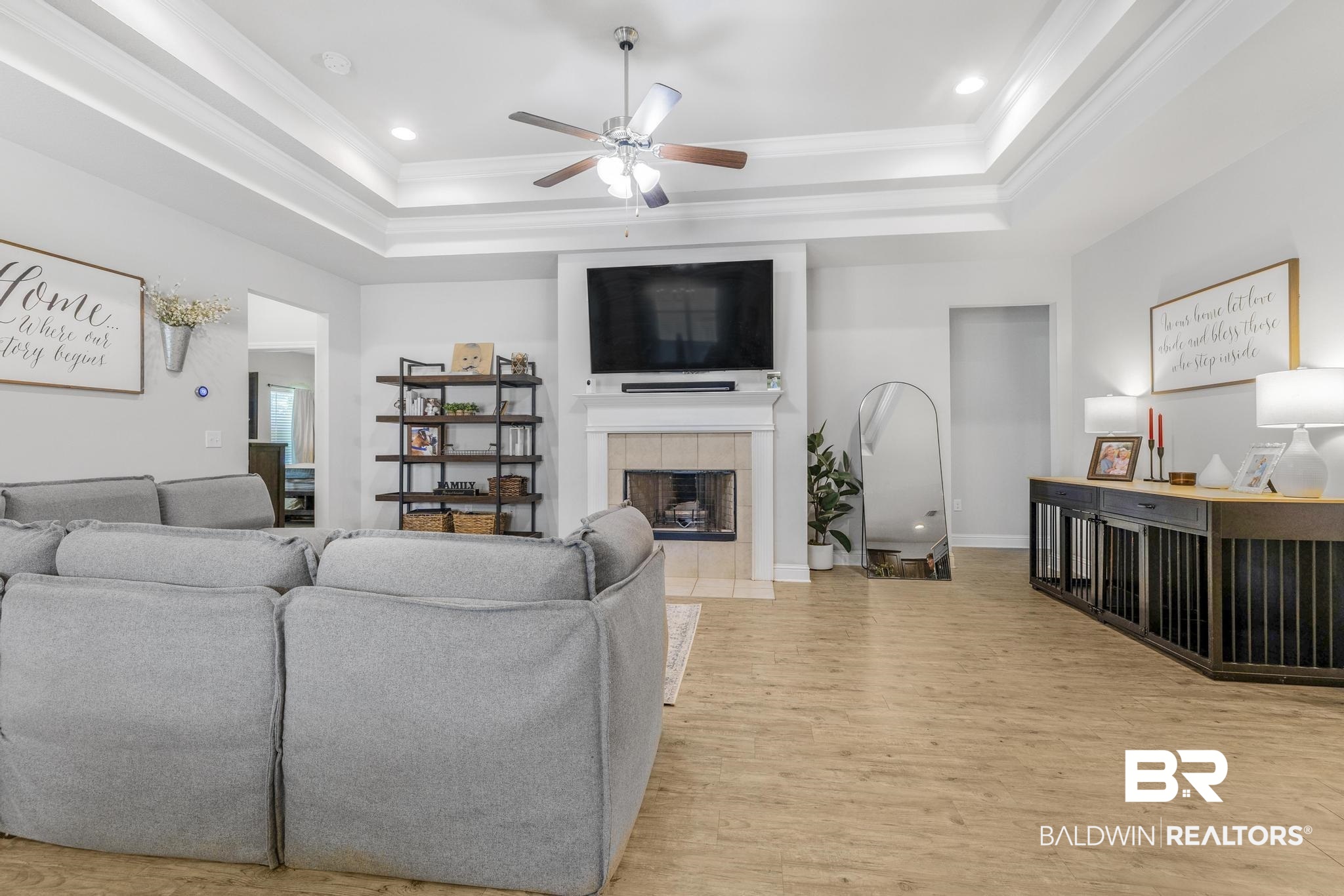 31336 Hoot Owl Road Daphne, AL 36527 - Photo 4 of 36 Living room featuring a tile fireplace, a tray ceiling, ornamental molding, light wood finished floors, and recessed lighting
