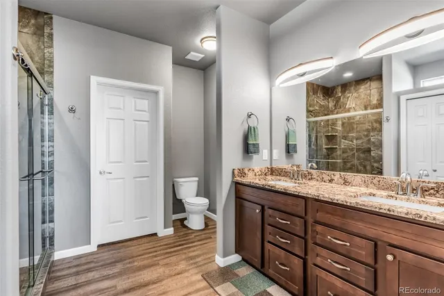 a bathroom with a granite countertop sink toilet and shower