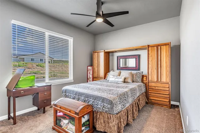 a bedroom with a bed a dresser next to a window