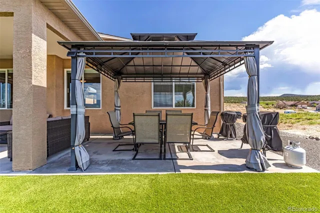 a view of a patio with table and chairs a barbeque with wooden fence
