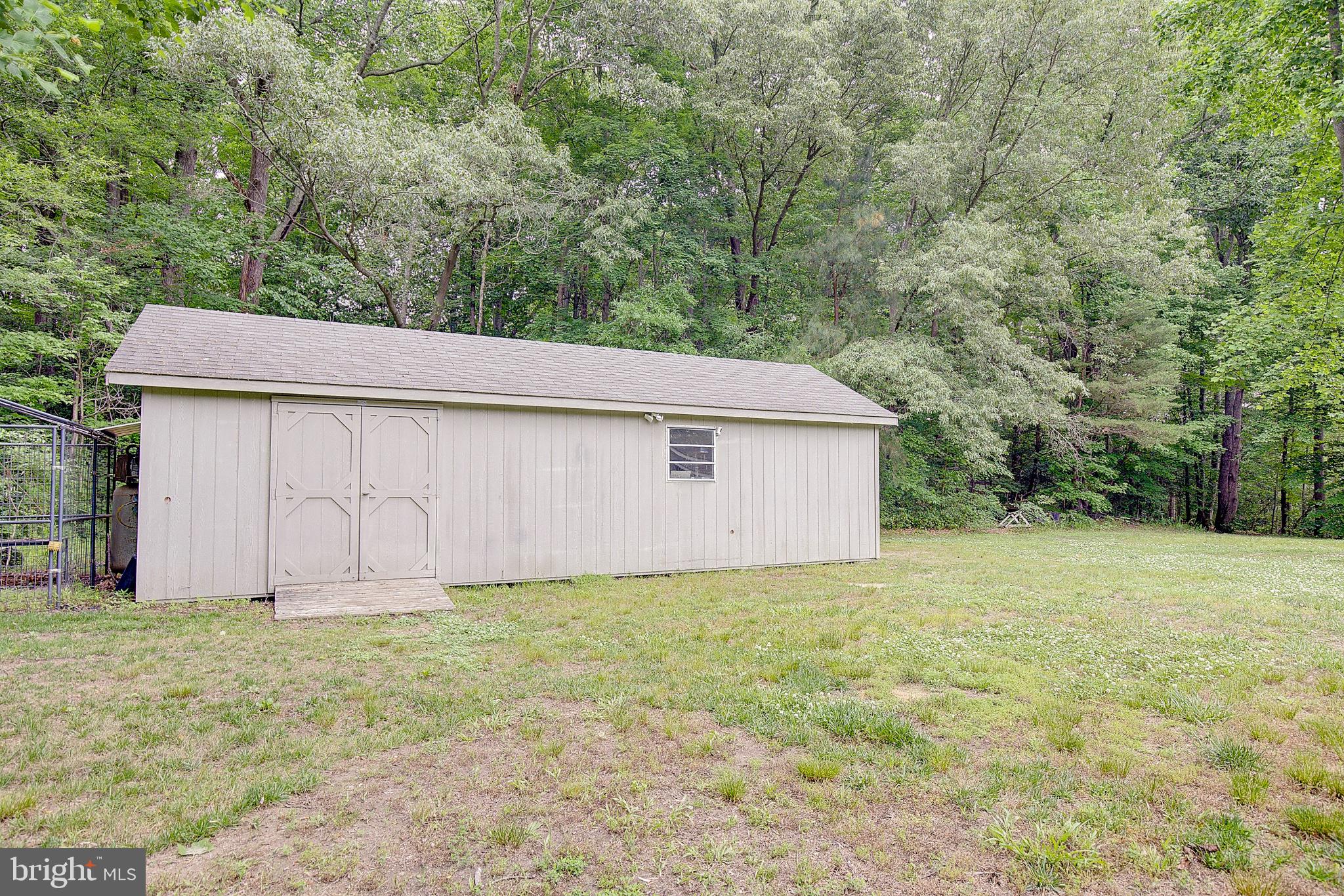 3081 Soper Road Huntingtown, MD 20639 - Photo 11 of 49 Charming shed nestled in lush greenery.