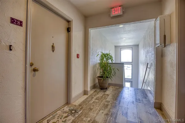 a view of a hallway with wooden floor
