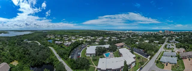 an aerial view of residential houses with outdoor space and trees