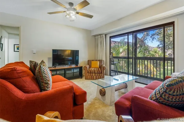 a living room with furniture a large window and a flat screen tv