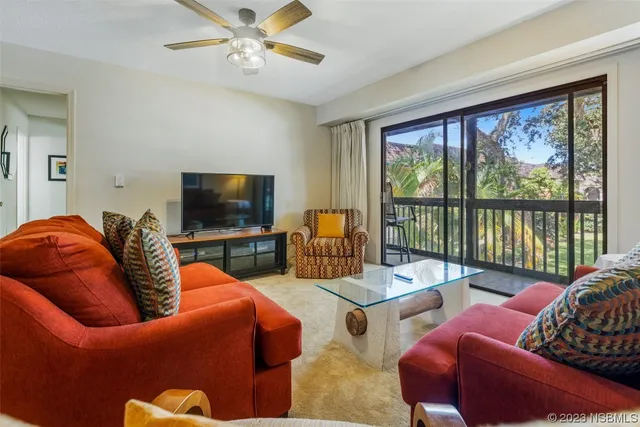 a living room with furniture a large window and a flat screen tv