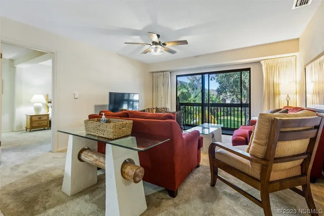 a living room with furniture and a floor to ceiling window