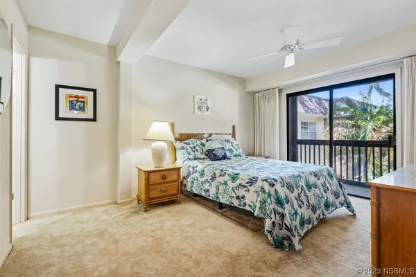a bedroom with a bed painting and a large window