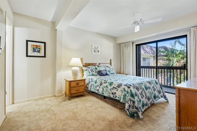 a bedroom with a bed painting and a large window